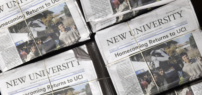 Stacks of the New University newspaper with the headline "Homecoming Returns to UCI" and a photo of mascot Peter the anteater posing with students above the fold