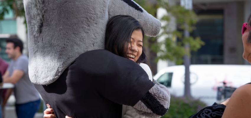 Grad studies student hugging anteater