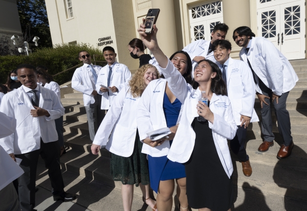 A group of first-year med students smile for pictures during the whitecoat ceremony