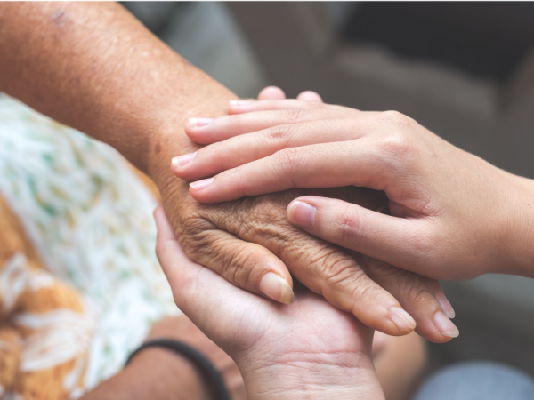 Two hands holding another person's hand