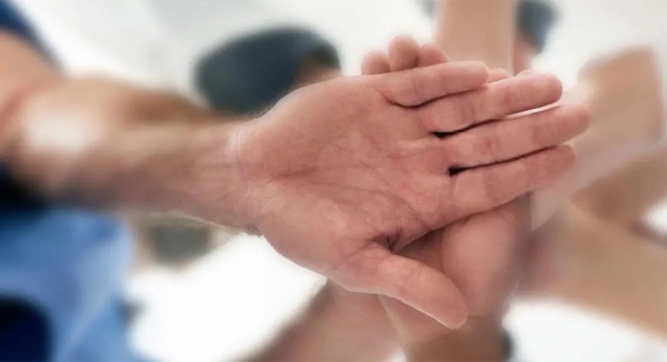 One hand in front and several hands behind it, displaying support