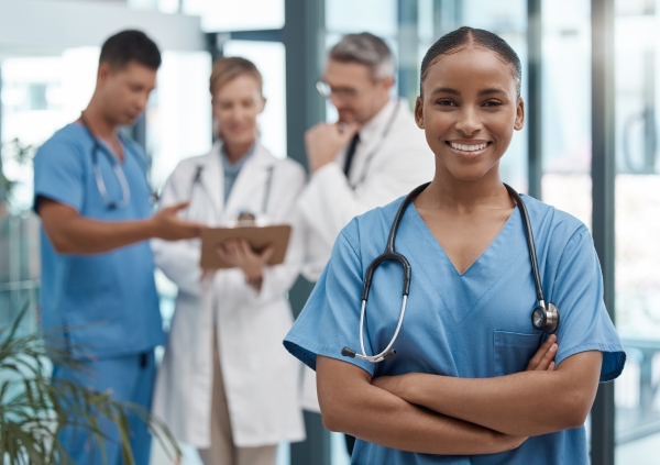 Doctor, portrait or black woman nurse with vision, motivation or leadership in hospital with team. Happy medical healthcare, wellness worker with smile at work for insurance, medicine success clinic