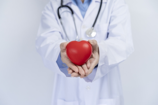 A photo of a physician holding/giving a foam heart