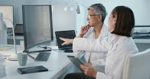 Science, tablet or computer with a woman and intern in laboratory for research or innovation. Collaboration, medical and study with a scientist team working in a lab for discovery or breakthrough