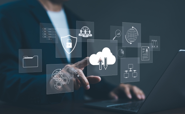 Person using a laptop, interacting with a holographic display of cloud computing and security icons.