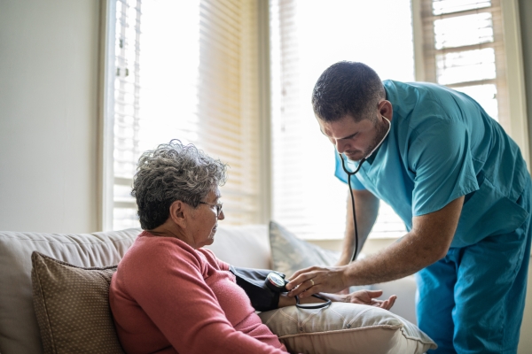 A woman gets her blood pressure measurement taken by a nurse