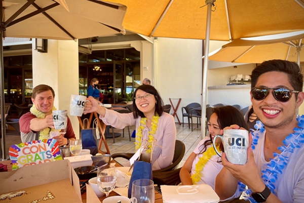 Four people in dining area with UCI merchandise 