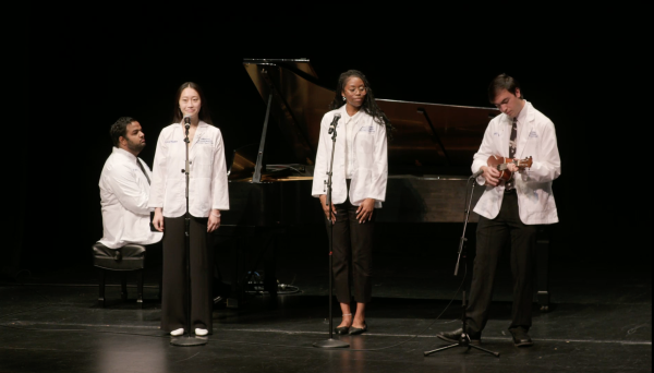Four medical students performing a musical piece on stage.