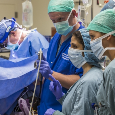 An anesthesiologist works with trainees in the OR