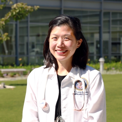 Helan Ma in her white coat outside VA Long Beach