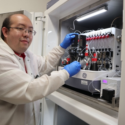 Specialist Christopher Liang sets up the automated radiosynthesis system, GE FXN Tracer Lab, for synthesis of novel fluorine-18 labeled radiopharmaceuticals in the lead-shielded enclosure.
