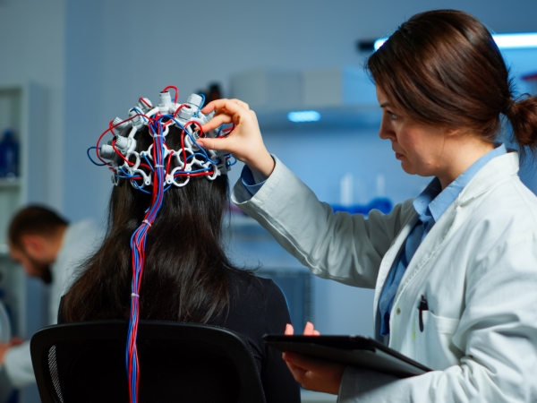 Doctor adjusting equipment to study patient brain activity