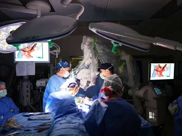 Two Department of Plastic Surgery faculty surgeons perform a procedure on a patient in the operating room