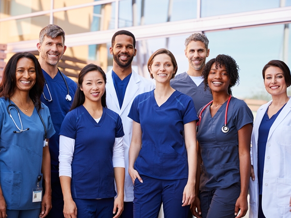 Group of medical professionals posing outside.