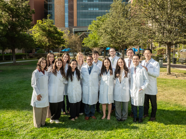A group photo of ENT Residents for 2031 outside with trees in the background