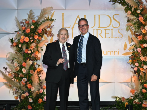 Steven Feinberg holds an award as he stands next to Dean Stamos