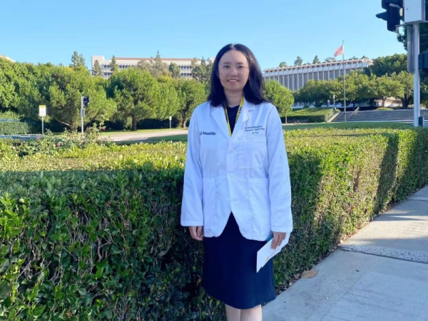 Xi Yu on campus at UC Irvine, wearing her white coat