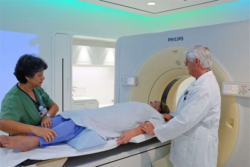 Two medical practitioners with patient preparing for CT scan