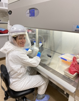 Person in a lab wearing PPE giving a thumbs up.