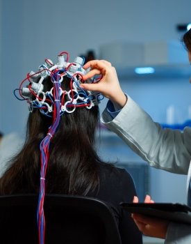 Doctor adjusting equipment to study patient brain activity