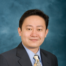 Kai Zheng headshot in suit and tie