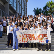 A group of students stand behind a banner that says "National Latino Physician Day: 6% is not enough."