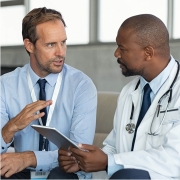 Physician wearing a white coat talking to a colleague