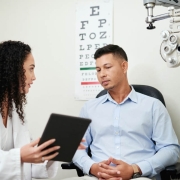 Eye doctor providing information to patient in office 