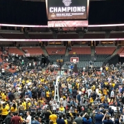 Crowd of people on basketball court after UCI wins Big West basketball tournament.
