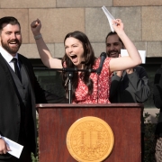 Student celebrates with her husband next to her at the podium after finding out where she'll be going for her residency.