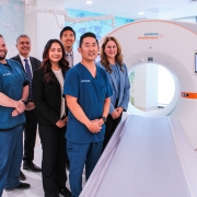 From left to right (standing by a photon CT machine): Frank Woodland, Dr. Vahid Yaghmai, Leticia Shubin, Dr. James Shi, Jason Oshiro, Julie Limfueco