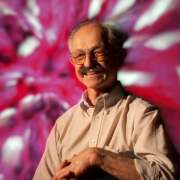 Dan Mercola with a pink and white abstract backdrop