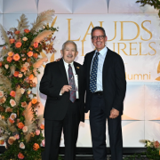 Steven Feinberg holds an award as he stands next to Dean Stamos