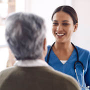 a doctor in blue scrubs talking to a patient