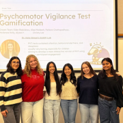 Six students stand in front of a projector that says Psychomotor Vigilance Test Gamification