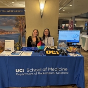 From left to right: Lindsay Cajuste and Anne Mai staffing the UCI Radiological Sciences Booth at AAR 25