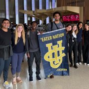 Group of students at LAX, holding an “Eater Nation UCI banner”