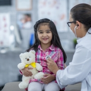 Pediatrician listening to a child's heart through a stethoscope during a checkup