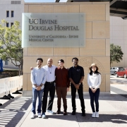 Five individuals standing in front of the UC Irvine Douglas Hospital at the University of California, Irvine Medical Center