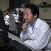 Pensive professor in white coat working in laboratory. 