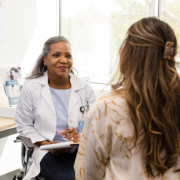 physician speaking with a patient in clinical setting