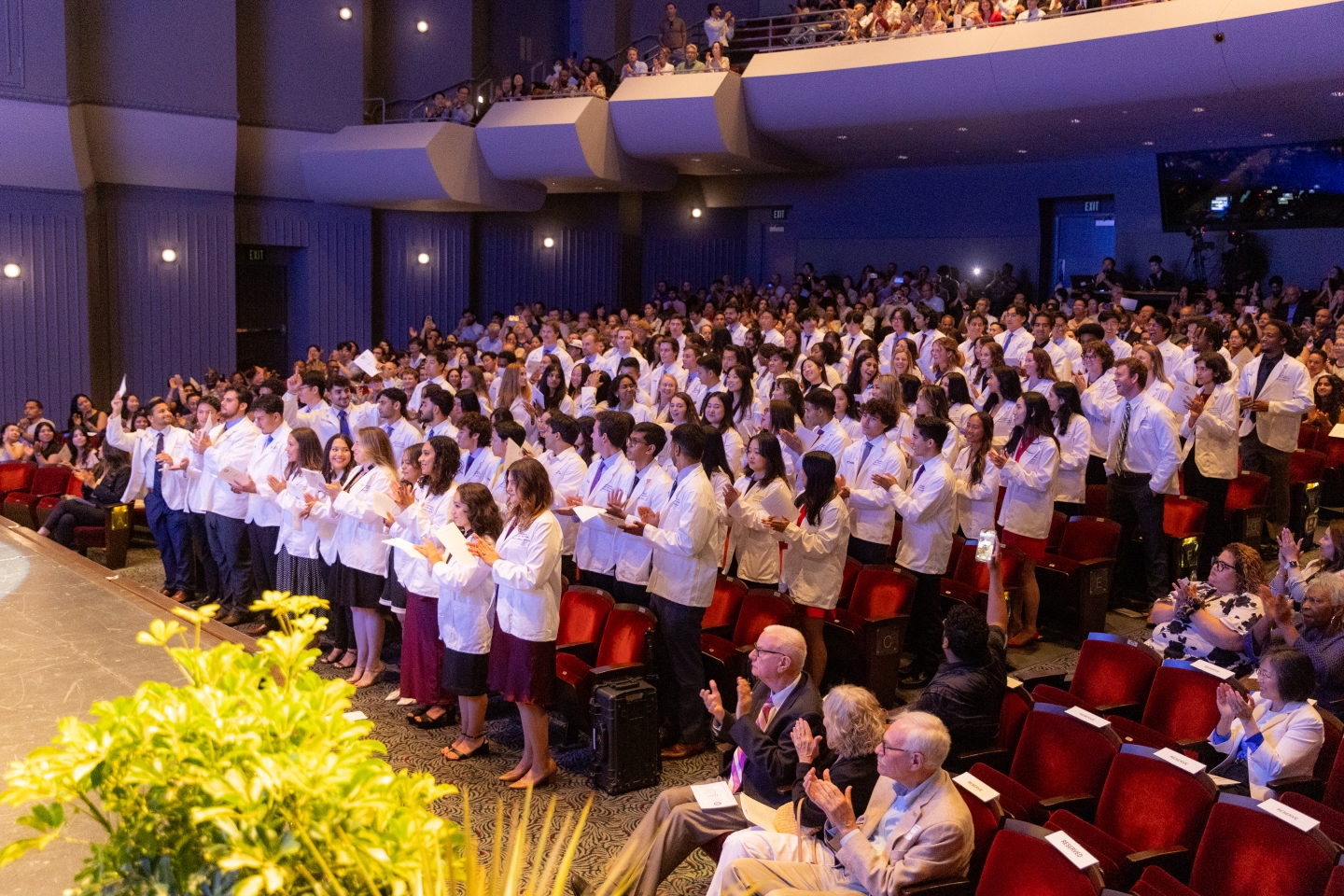 Students standing inside the Irvine Barclay Theater, reciting the Hippocratic Oath.
