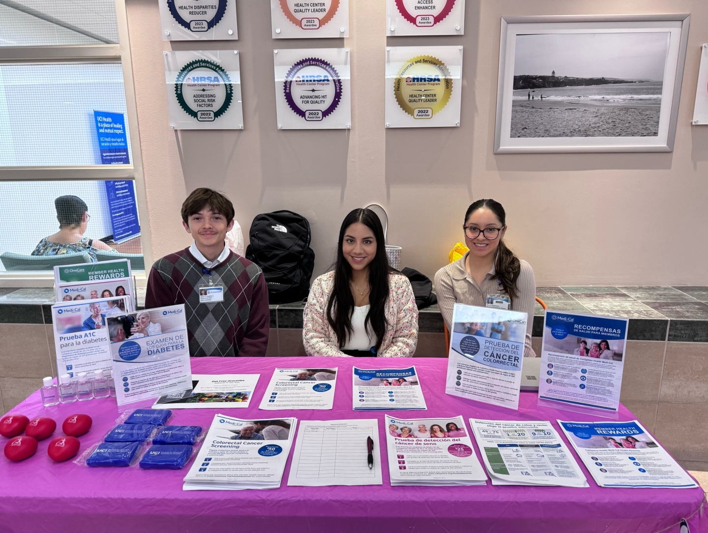 Three students sitting at a table with an assortment of flyers.
