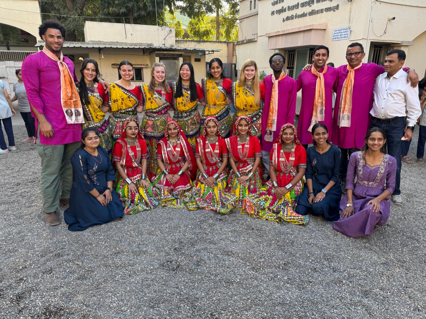 Group photo with everyone wearing colorful, traditional Indian clothing