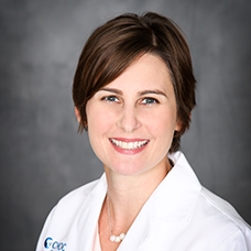 A headshot of Jennifer Lusk in whitecoat