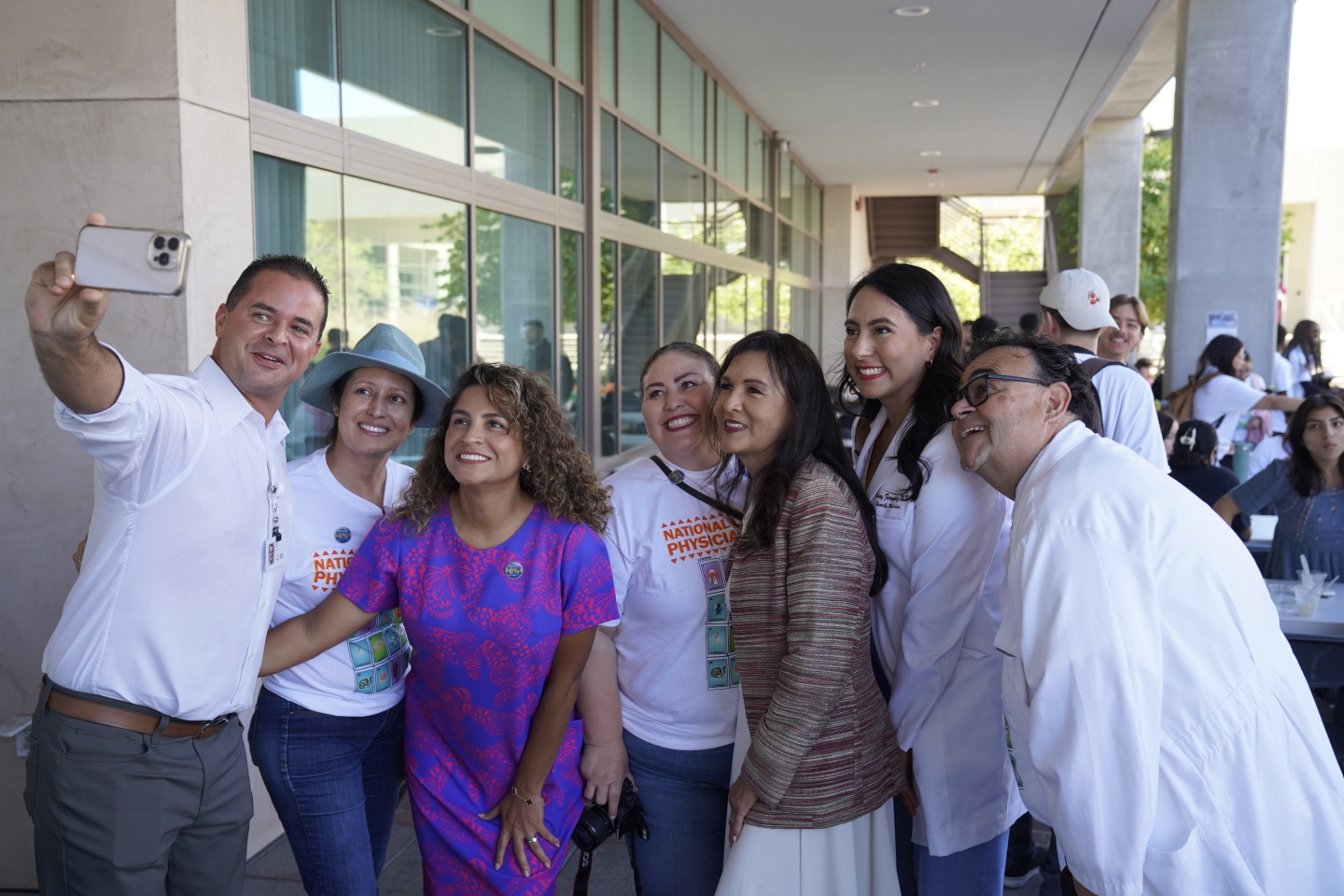 A man holds a cell phone to take a group selfie