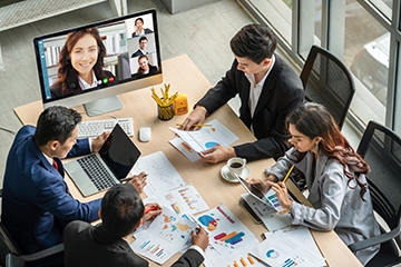 Business conference call with both remote and in-person colleagues attending