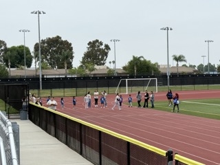 Young students stand around on the track for the SuperKids Health Expo, a UC Irvine pediatric resident-led initiative that started in 2011. This outreach event aims to engage and support our local community and raise awareness on childhood obesity.