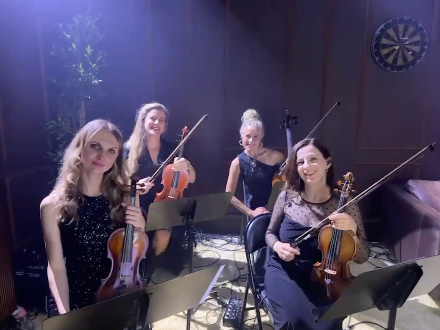 Zaaijer sits holding her viola, with three other musicians.