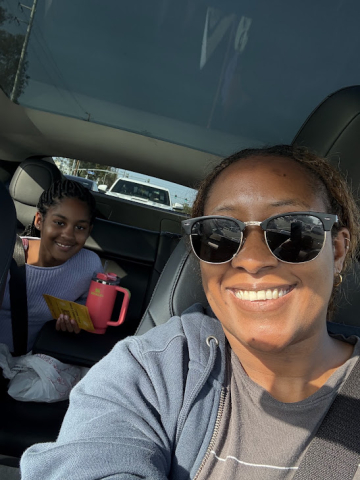 Chiru takes a selfie in the car, with her daughter in the back seat. 